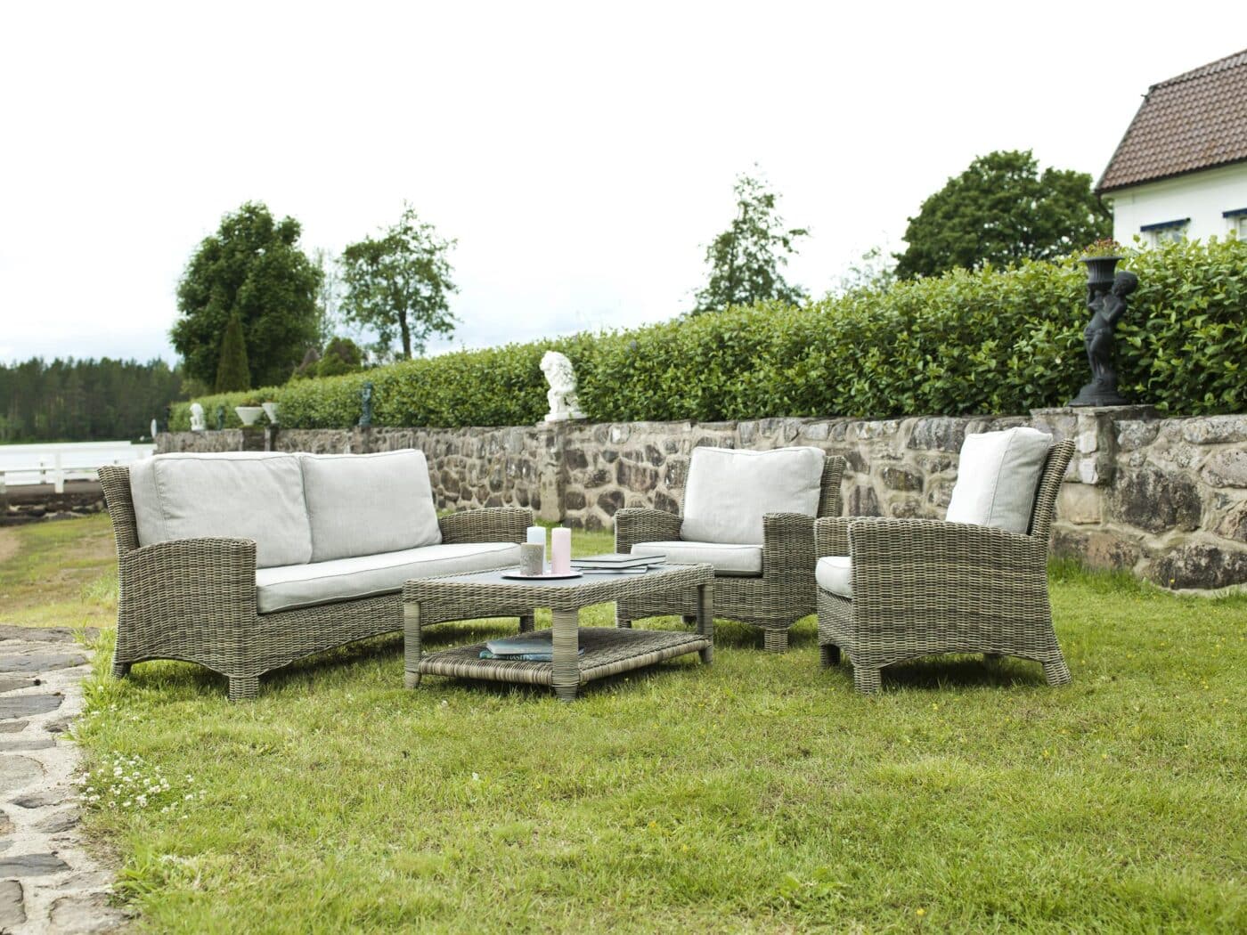 Hillerstorp Dallas Soffgrupp i naturfärgad konstrotting och grå dynor. Soffa, två fåtöljer och loungebord med stenliknande glasskiva.