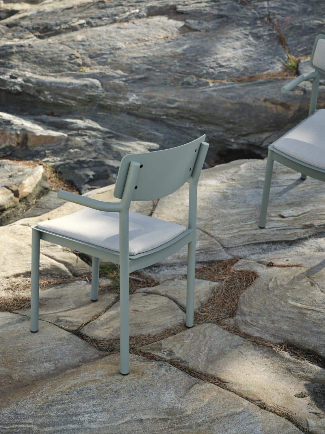 Brafab Gusty Karmstol har stomme i dammigt matt grön aluminium och sits/rygg i askfärgad akryl.